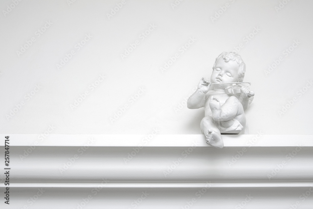 White plaster angel sculpture with a violin White plaster angel sculpture with a violin