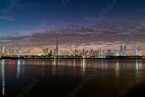 Morning, sunrise or dusk in Dubai. Dawn over Burj Khalifa. Beautiful colored cloudy sky over Dubai downtown . Glow over buildings or skyscrapers © HLEB