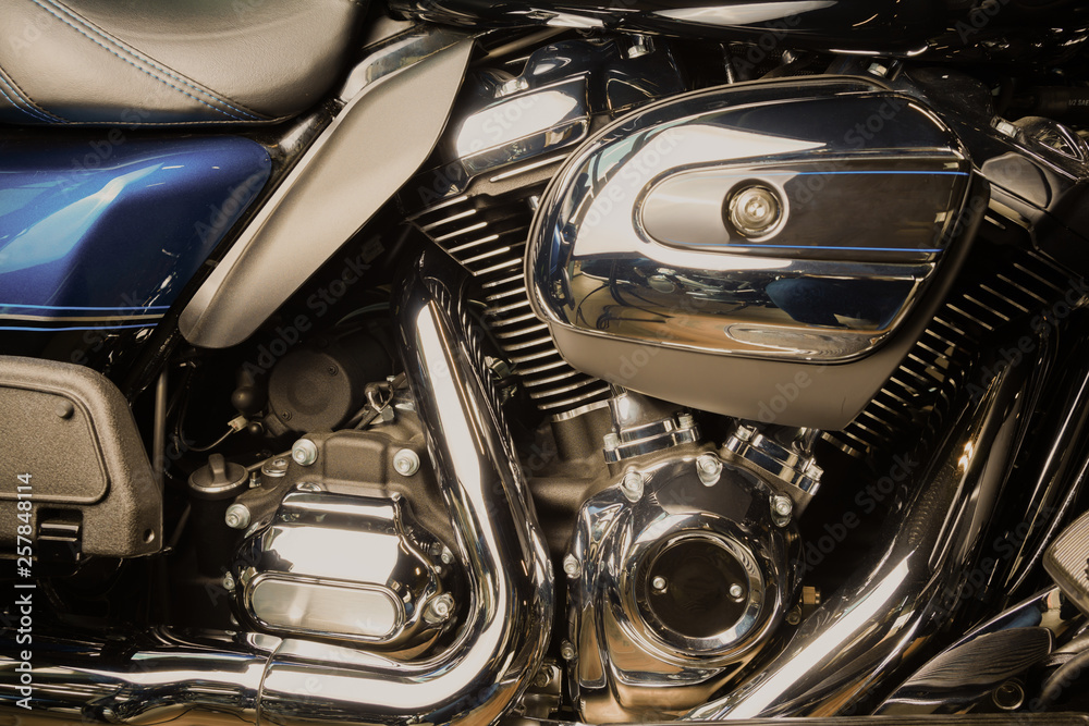 Motorcycle internal combustion engine with air cooling, close-up, detail, macro. Engine parts, cylinder head, ignition, exhaust pipe, air-intake manifold Motorcycle internal combustion engine with air cooling, close-up, detail, macro. Engine parts, cylinder head, ignition, exhaust pipe, air-intake manifold
