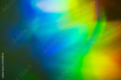 Defocused blue and yellow lights on dark background. Bokeh lens flare glow optical effect.