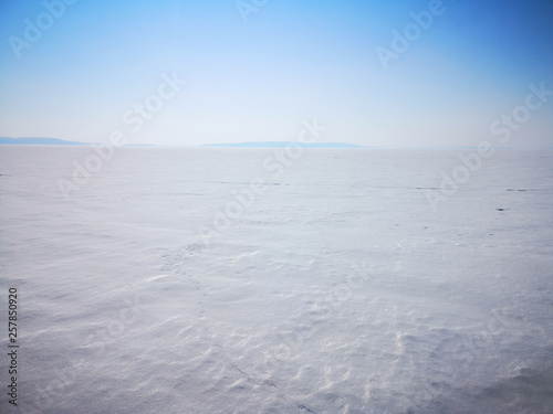 View of a large frozen lake in an empty winter landscape in Russia