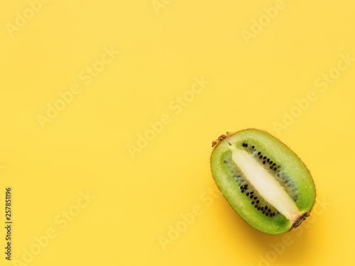 Isolated kiwi. One kiwi fruit cut in halves isolated on yellow  background with clipping path