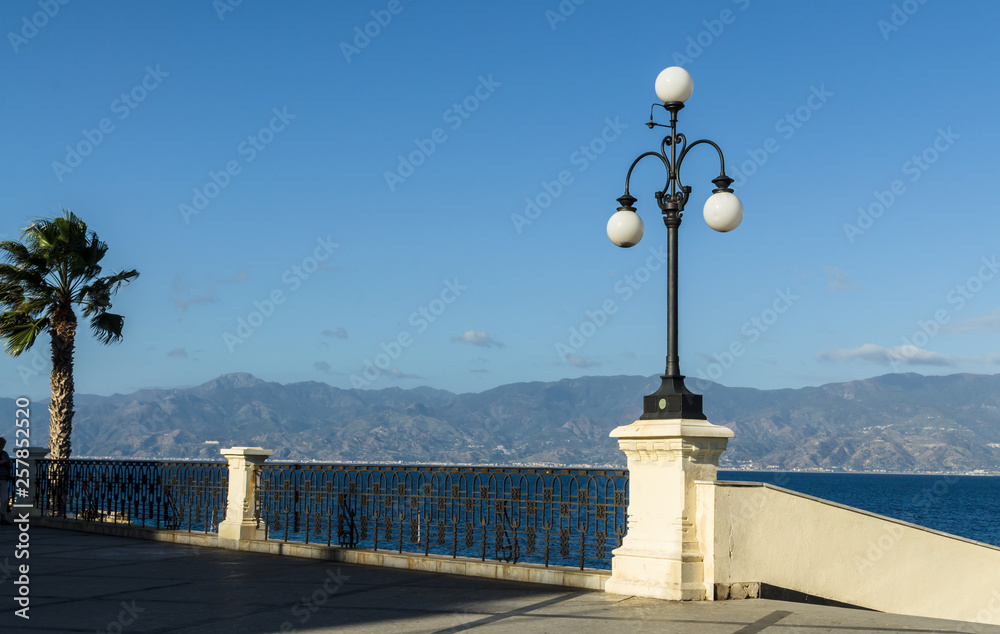 View of the Reggio di Calabria promenade Lungomare Falcomata and Strait of Messina connected Mediterranean and Tyrrhenian sea and Sicilia island background, Reggio Calabria, Italy