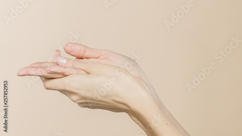 A003_C01Female hands are creaming on a beige background