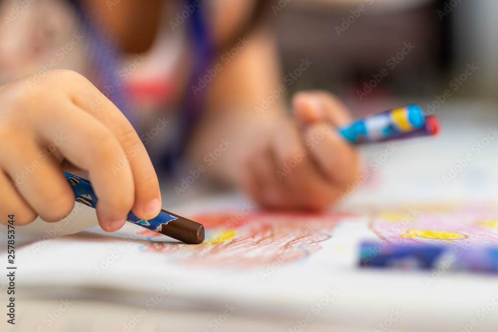 Close up of little hands coloring with Crayon Close up of little hands coloring with Crayon