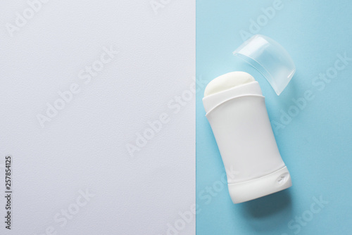 white deodorant or antiperspirant on blue background for body skin care concept . copy space