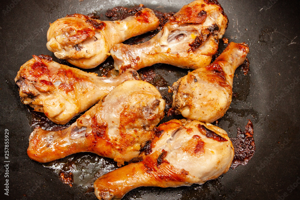 Roasted chicken legs on the black background. Top view. Roasted chicken legs on the black background. Top view.