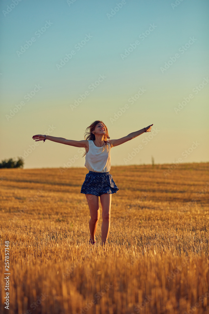Cute young woman jumping in a wheat field. Cute young woman jumping in a wheat field.