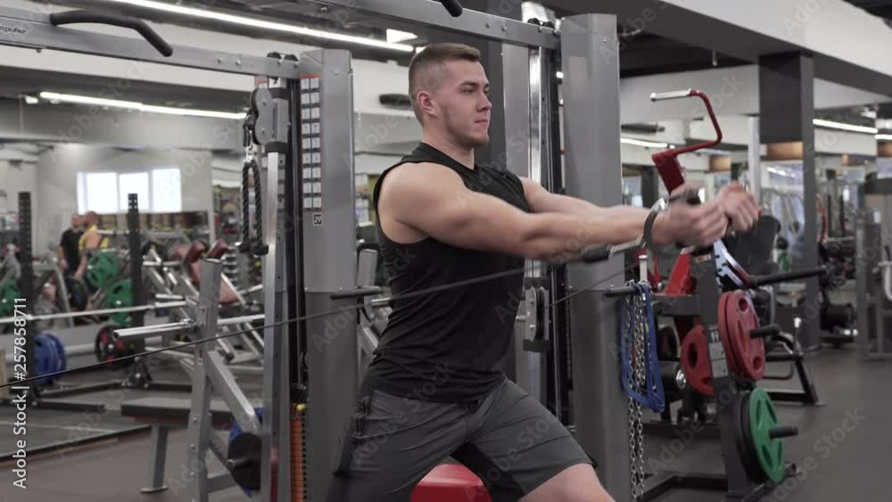 Strong Young Man Working Out in Modern Gym. Strong Young Man Working Out in Modern Gym.
