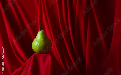 green pear on red background