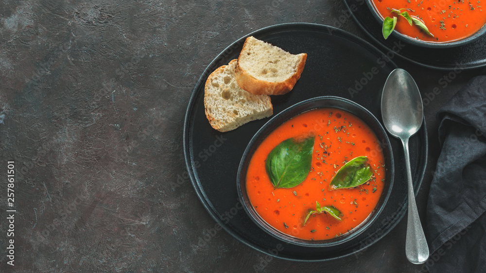 Gaspacho soup in black bowl. Traditional spanish cold soup puree gaspacho or gazpacho on dark background with copy space for text. Top view or flat lay. Banner Gaspacho soup in black bowl. Traditional spanish cold soup puree gaspacho or gazpacho on dark background with copy space for text. Top view or flat lay. Banner