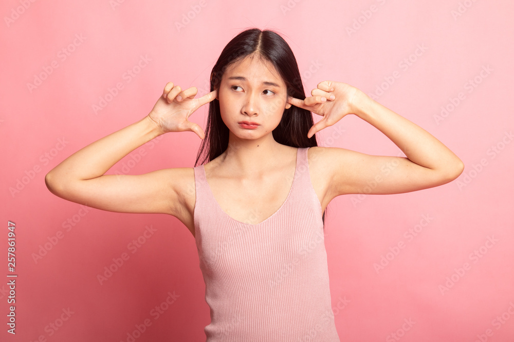 Young Asian woman block both ears with fingers. Young Asian woman block both ears with fingers.