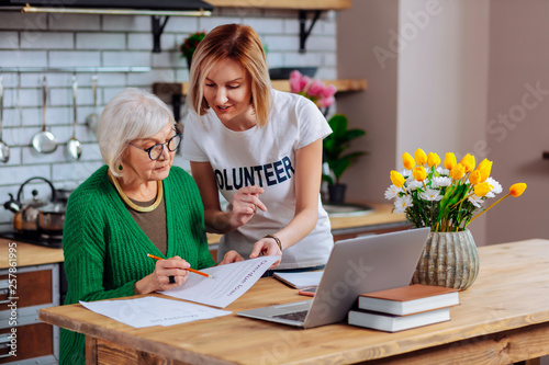 Volunteer trying to persuade elderly woman to sign overdue loan