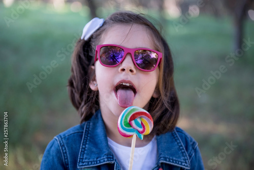 Pretty girl enjoying the lollipop in the park