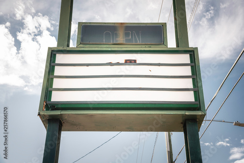 An old, dilapitated and empty changeable letter sign board on a street.