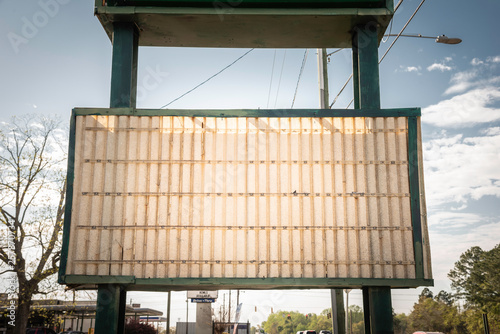 An old, dilapitated and empty changeable letter sign board on a street. photo