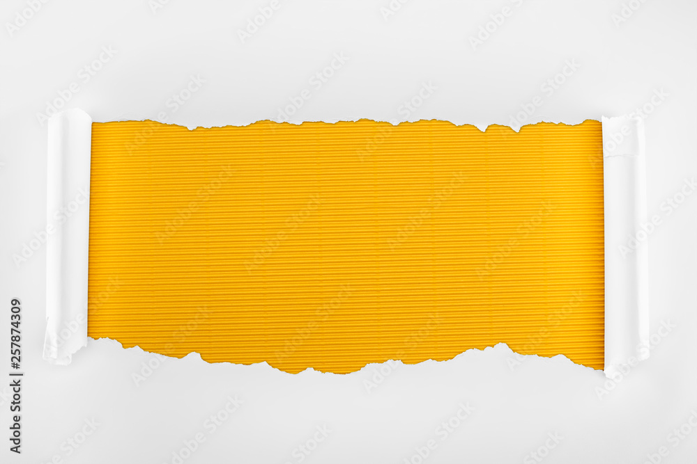 ripped white textured paper with curl edges on yellow striped background ripped white textured paper with curl edges on yellow striped background