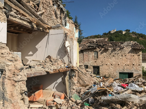 A badly damaged house in rural Italy after an earthquake, the external wall has been destroyed exposing the inside of the house.