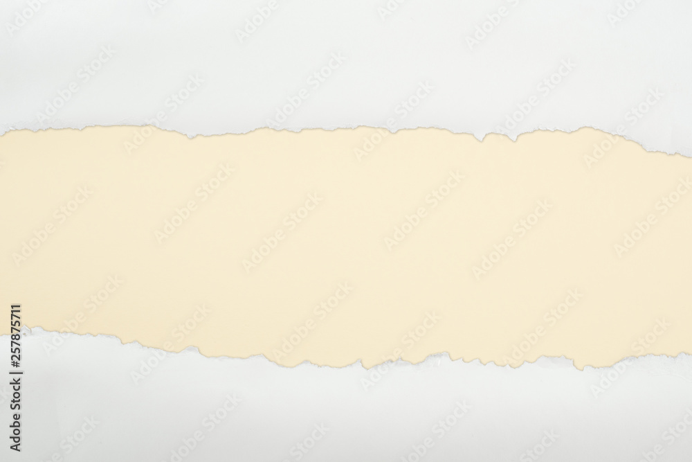 ragged white textured paper with copy space on beige background