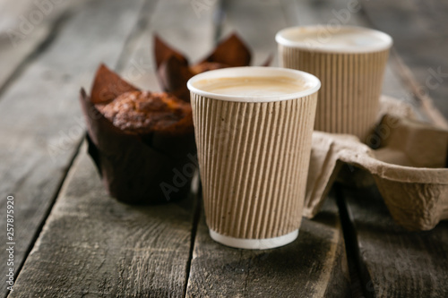 Foto Coffee to go with muffin on wood background, copy space