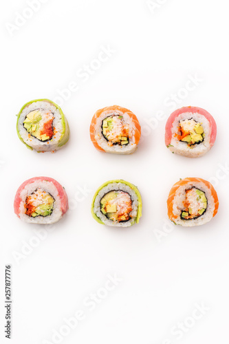 Flat lay with colorful sushi rolls with crab meat on white background