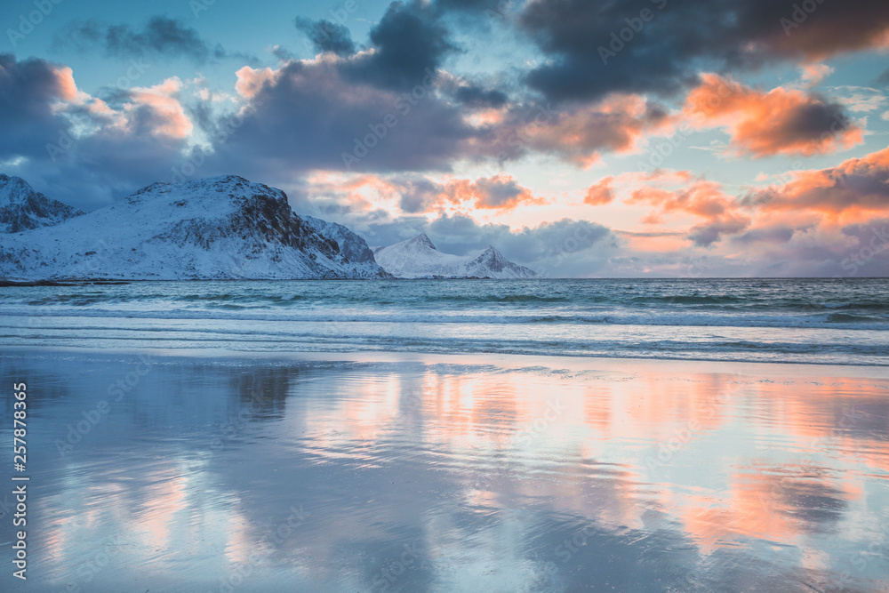 Crystal clear winter beach with mountains in the background in Norway