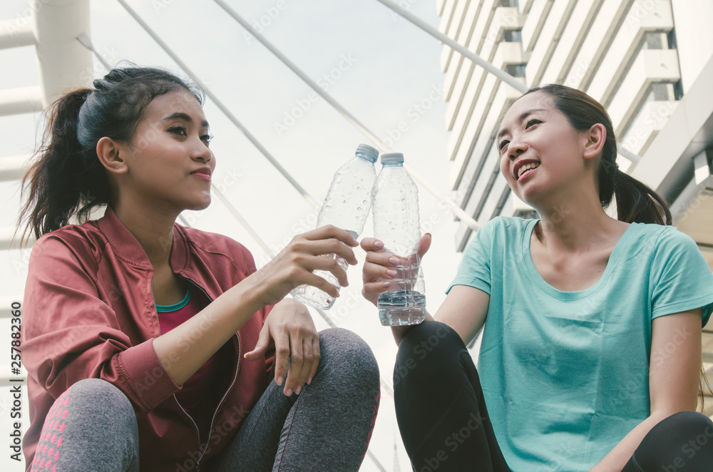 Beautiful fitness athlete asian woman drinking water after exercise. Beautiful fitness athlete asian woman drinking water after exercise.