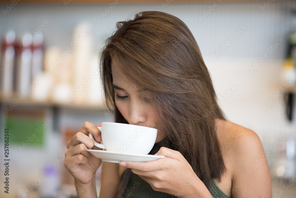 Young beautiful asian woman drinking coffee in cafe. Young beautiful asian woman drinking coffee in cafe.