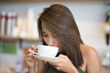 Young beautiful asian woman drinking coffee in cafe.