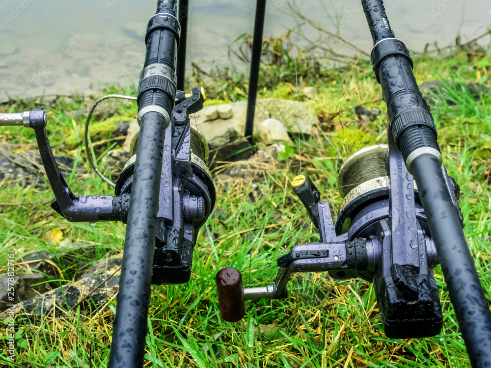 Fishing rods with reels waiting for fish to bite in rainy weather. Fishing rods with reels waiting for fish to bite in rainy weather.