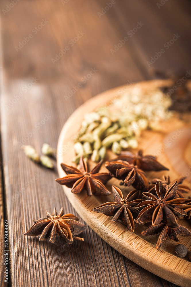 Seasoning on a textured wooden background close-up and copy space. Cinnamon, star anise, fennel, cloves, seasoning tea masala as a texture Seasoning on a textured wooden background close-up and copy space. Cinnamon, star anise, fennel, cloves, seasoning tea masala as a texture