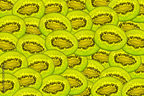 Pattern made from fresh kiwi deliciosa slices overlapping, overhead view, flatlay. Fruit background.