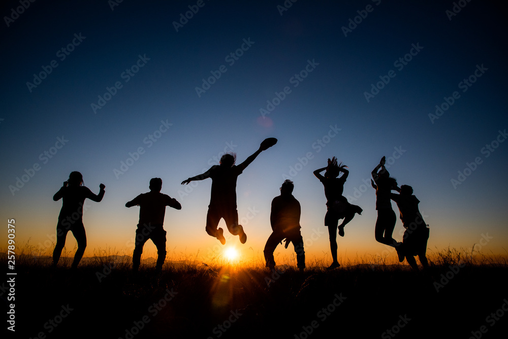 Silhouettes group of people on  mountain with sunset