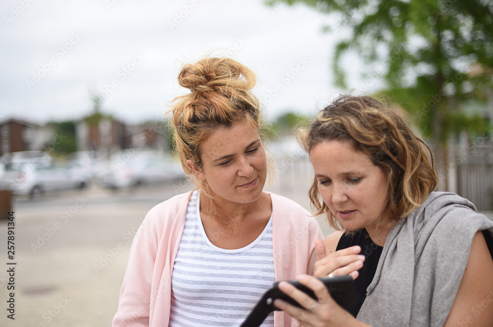 two young women with a mobile phone two young women with a mobile phone