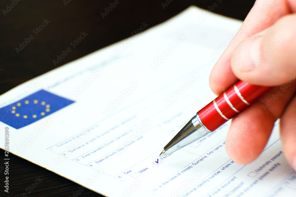 Schengen visa, questionnaire. Hand with pen completing a questionary. Schengen visa, questionnaire. Hand with pen completing a questionary.