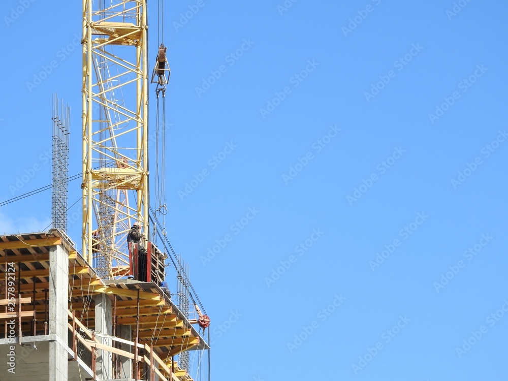 Aerial photograph of an unrecognized civil engineer without a face, watching the work of roof builders on the construction site. The concept of building with copy space. Aerial photograph of an unrecognized civil engineer without a face, watching the work of roof builders on the construction site. The concept of building with copy space.