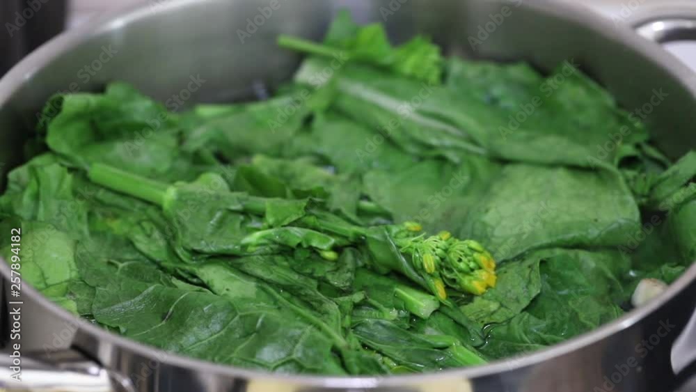 green fresh vegetables boiling in water in iron pot green fresh vegetables boiling in water in iron pot