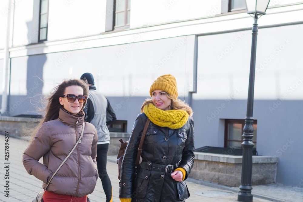 Obraz premium Two happy Caucasian women walking together, having fun and laughing