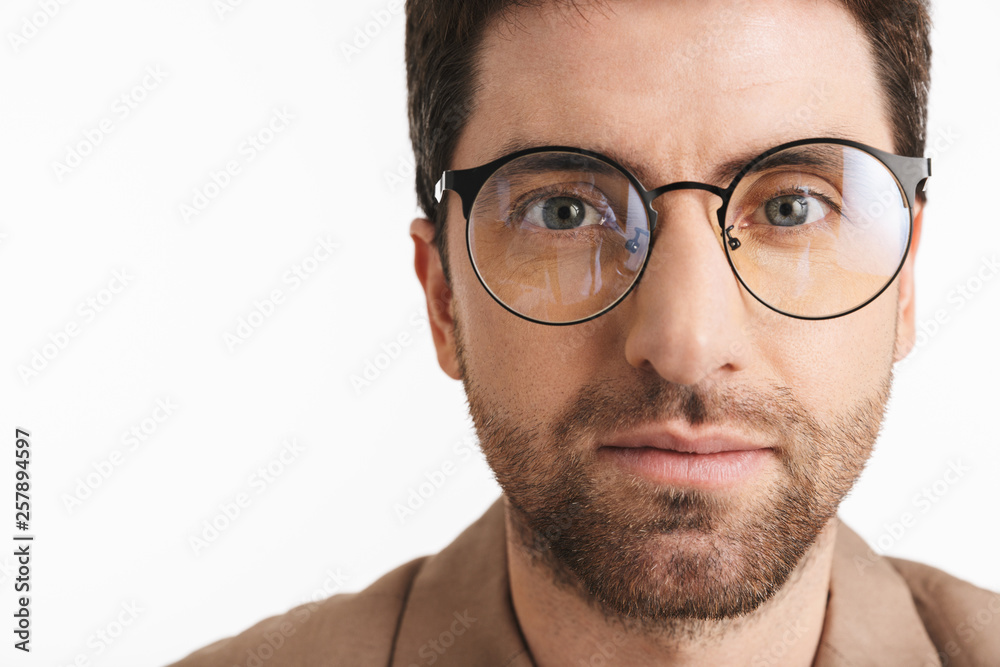 Image of brunette man 30s with stubble wearing jacket and eyeglasses posing on camera Image of brunette man 30s with stubble wearing jacket and eyeglasses posing on camera