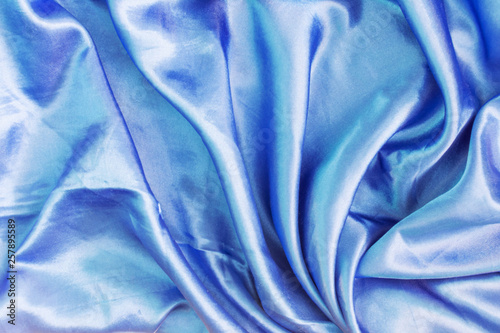 The texture of the dark blue silk fabric is folded. Empty abstract background for layouts.