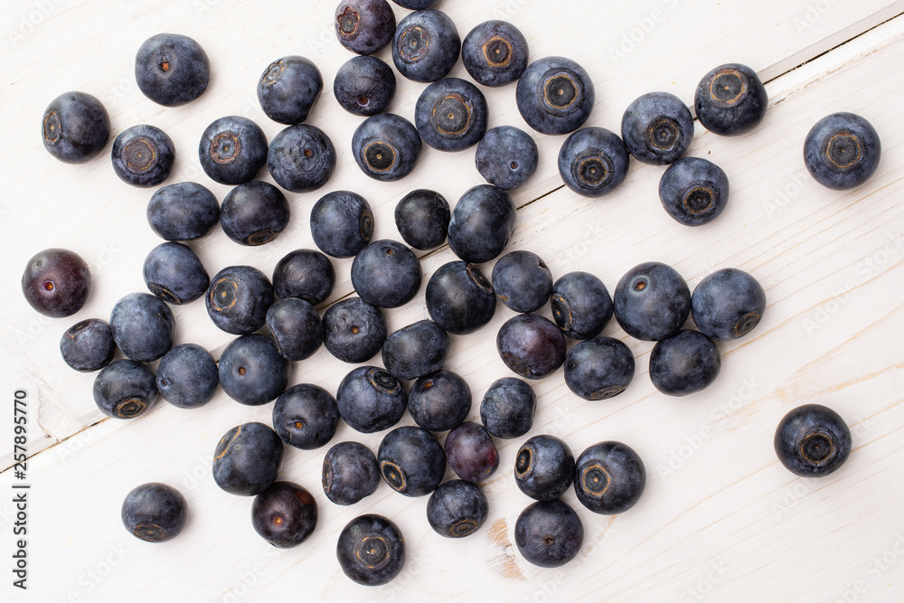 Lot of whole fresh sweet purple blueberry american flatlay on white wood Lot of whole fresh sweet purple blueberry american flatlay on white wood