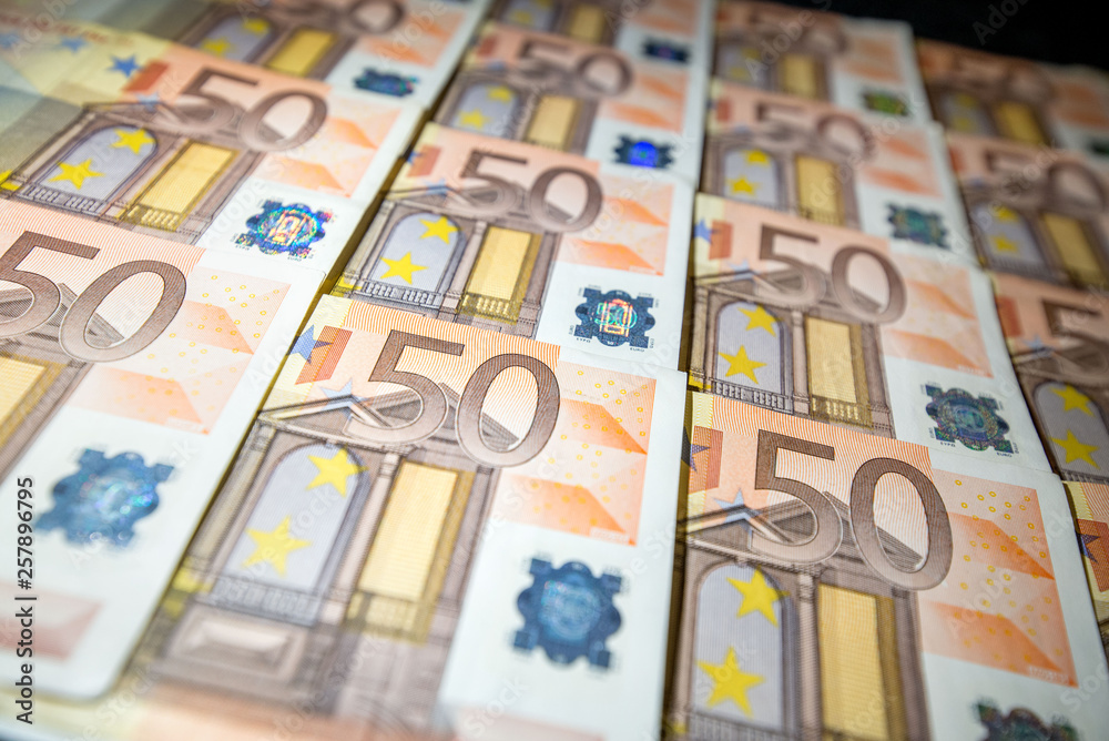 50 euro paper money on black background. Hundreds of banknotes. Concept of cash flow, finances, rich people, millionaire and successful business. 50 euro paper money on black background. Hundreds of banknotes. Concept of cash flow, finances, rich people, millionaire and successful business.