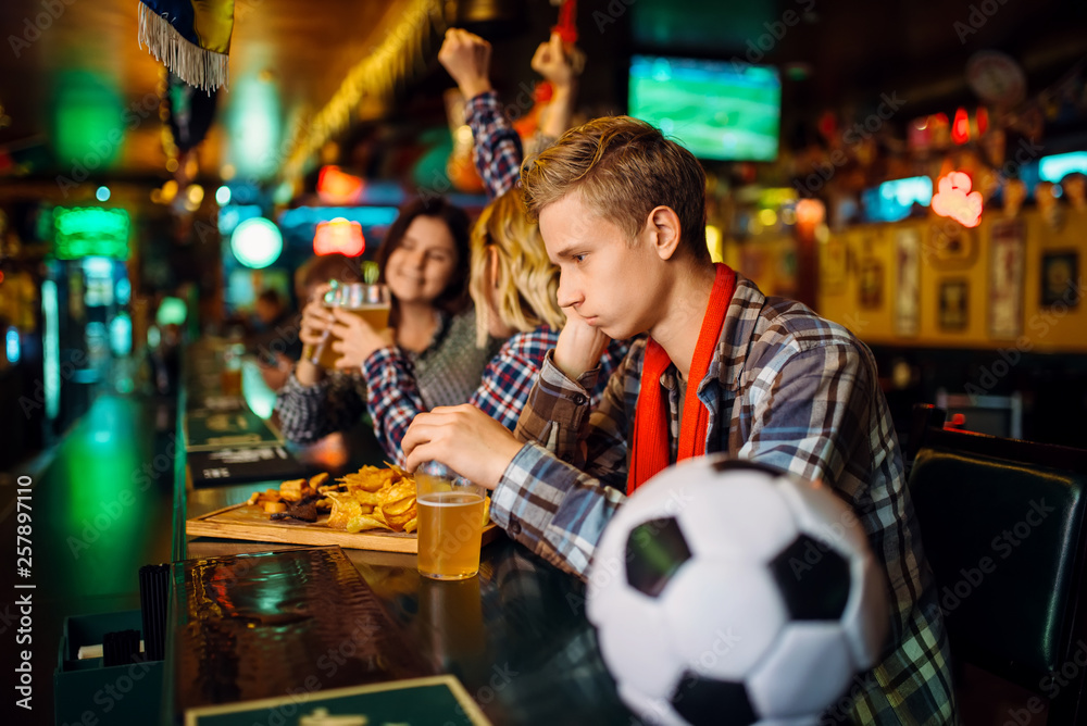 Upset football fan at the counter in sports bar Upset football fan at the counter in sports bar