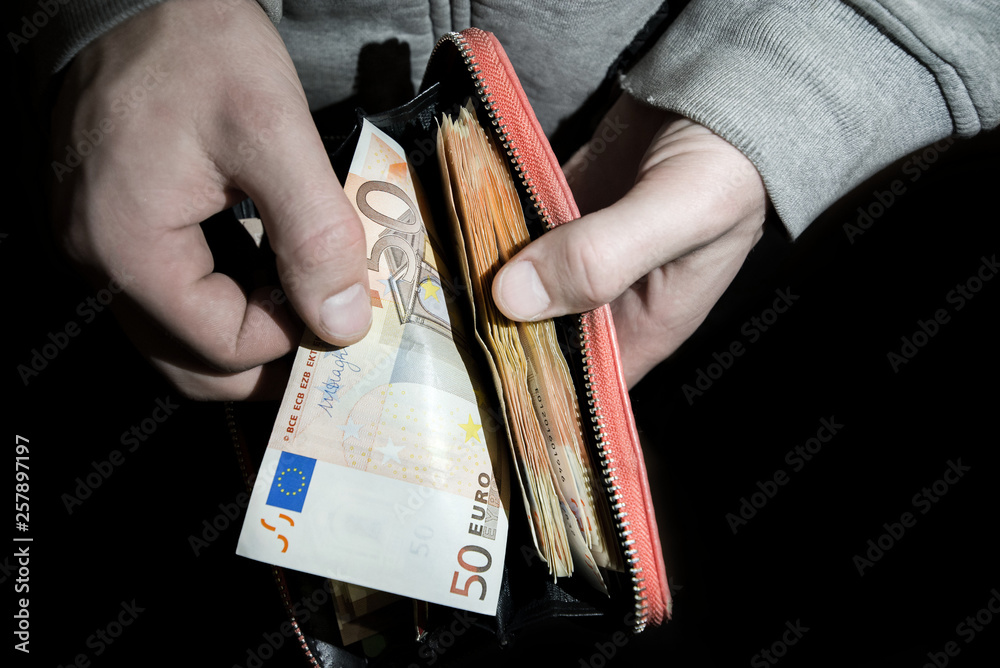 Vrijgevigheid punch fluweel Man holding wallet full of euro money bills and banknotes. Concept of  burglary, theft stealing cash in the middle of night. Rich people, savings  or spending money. Counting payment. Photos | Adobe