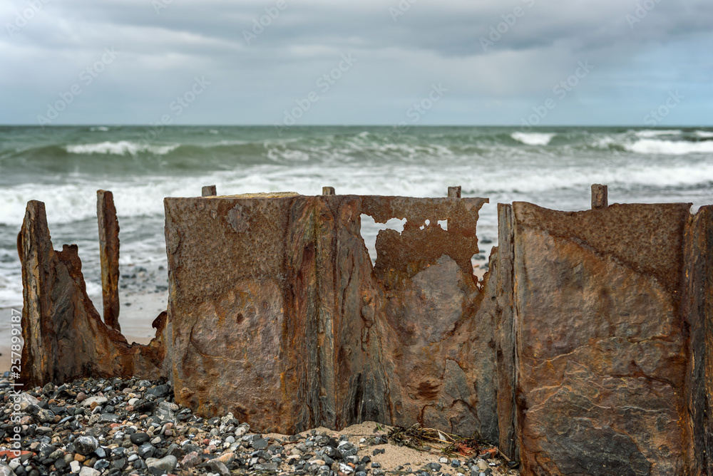 Old wall with stones and rusted steel plates on the island of Rügen on the Baltic Sea. Concept: postcards or vacation and travel