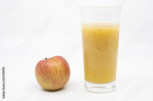 Glass of homemade apple juice with a red apple