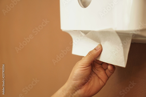 hand pulling tissue paper in tissue box.