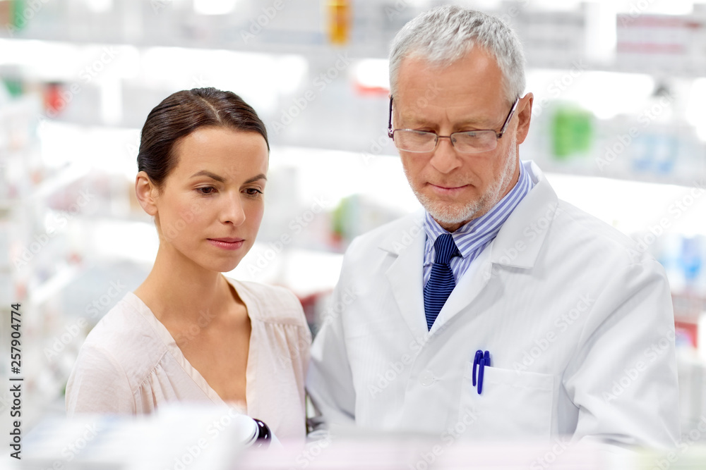 medicine, healthcare and people concept - senior apothecary with drug and female customer at pharmacy medicine, healthcare and people concept - senior apothecary with drug and female customer at pharmacy