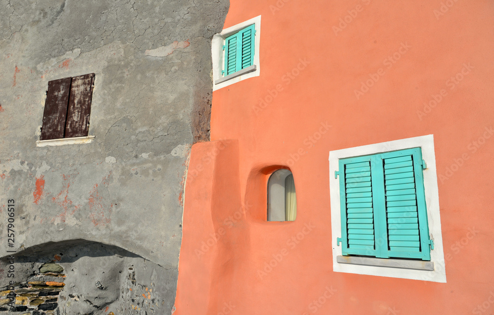 Picturesque corner with colorful green windows and orange old building facade in beautiful village Tellaro, Liguria Italy 
