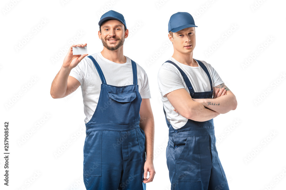 two movers in uniform looking at camera and showing empty business card isolated on white two movers in uniform looking at camera and showing empty business card isolated on white